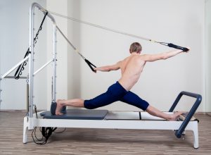 Pilates reformer workout exercises man at gym indoor